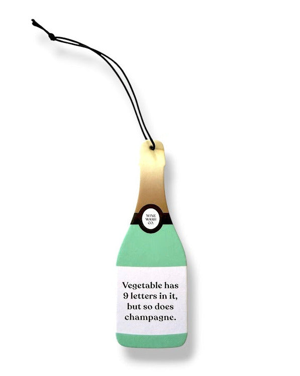 Green champagne bottle-shaped air freshener with a humorous message on a white background